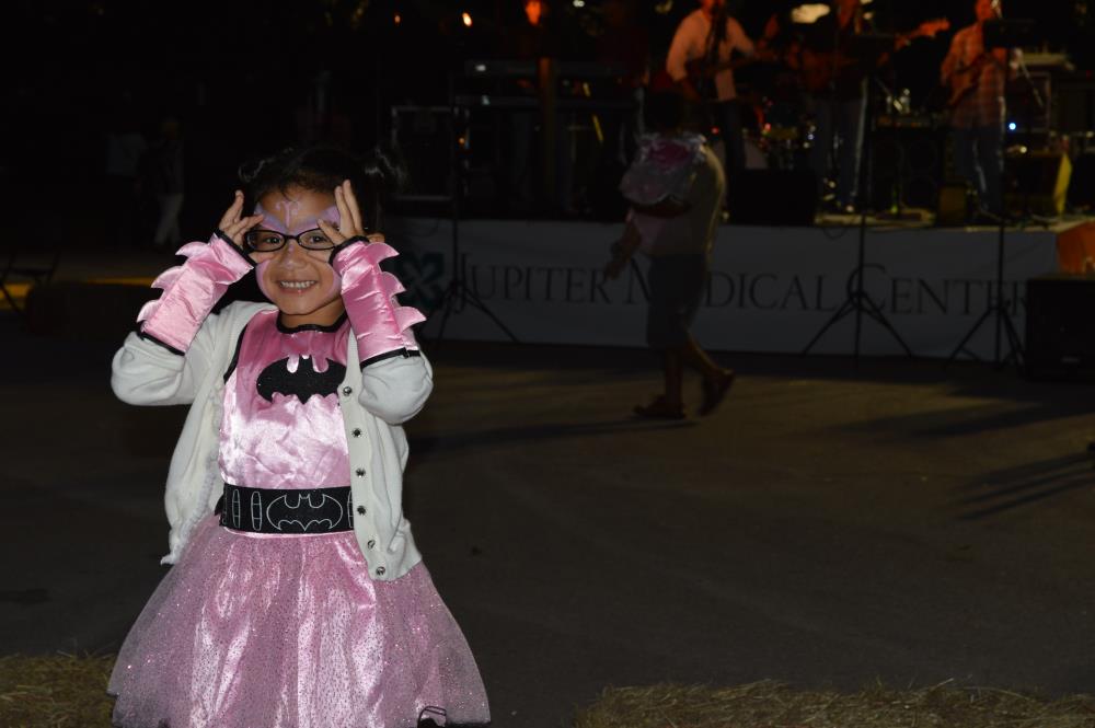 Young girl in pink batman dress and white coat